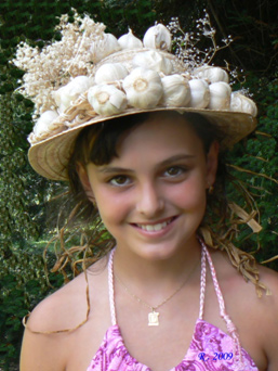 Děvče s česnekem na klobouku